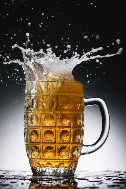 istock splashes of cold light beer in mug 900845232