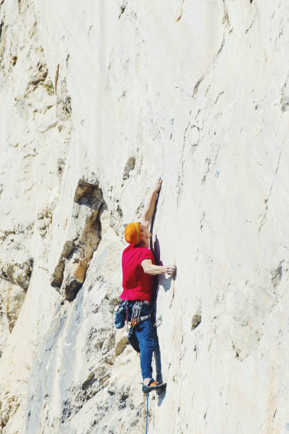 istock Rock climber ascending a challenging cliff. Extreme sport climbing. Freedom, risk, challenge, success. 900845520