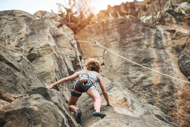 若い女性のキャニオン - 屋外トレーニング強いクライマーで岩壁を登る - 旅行、アドレナリンと極端な危険なスポーツ コンセプト - 彼女の体に焦点を当てる - rock climbing 写真 ストックフォトと画像