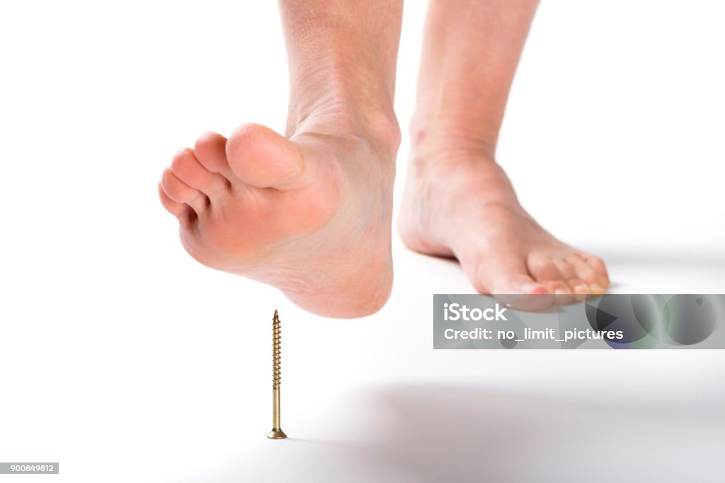 Caminar descalzo sobre un tornillo pico - Foto de stock de Subir o bajar escalones libre de derechos