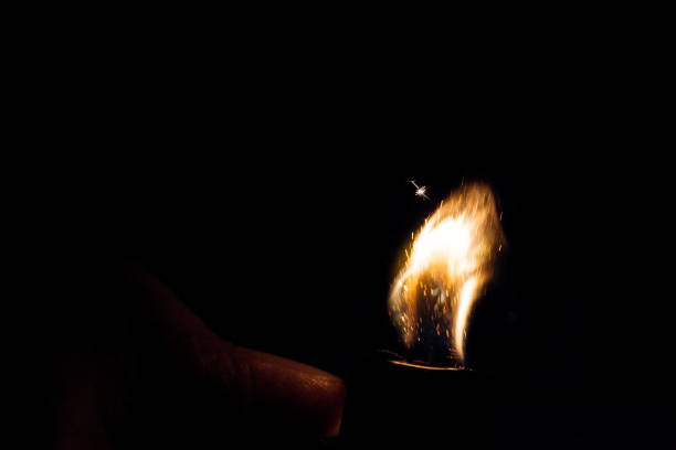 istock Close up view of real sparking light from lighter in dark black background 900850008