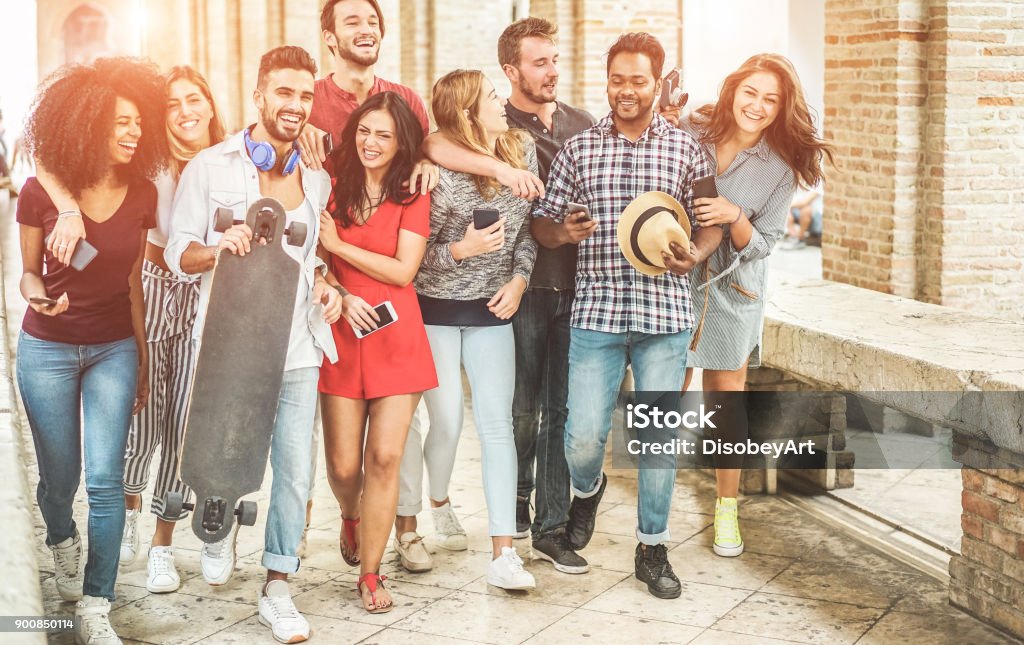Happy friends having fun walking in city center - Young students laughing and enjoying time together outdoor - Youth, trendy lifestyle and friendship concept - Main focus on right people University Student Stock Photo