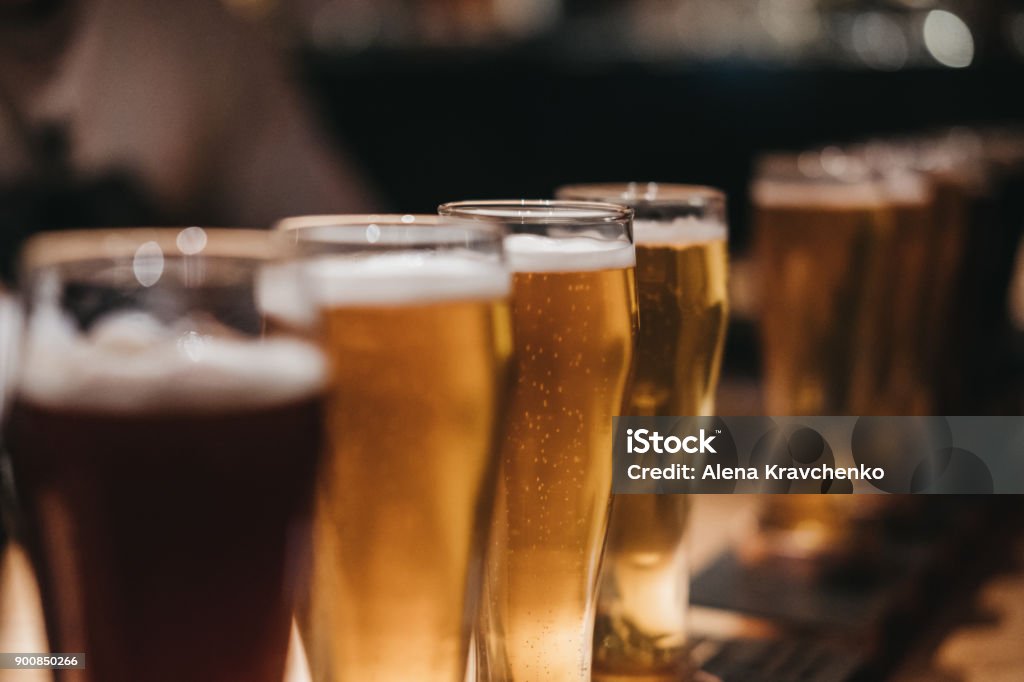 Close up of a rack of different kinds of beers, dark to light, on a table. Close up of a rack of different kinds of beers, dark to light, on a table. Selective focus. Brewery Stock Photo