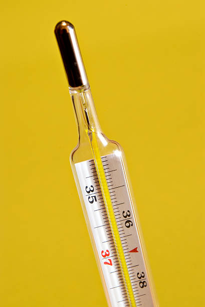 Thermometer on yellow stock photo