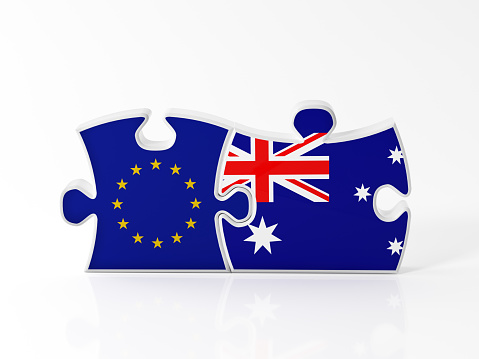 Jigsaw puzzle pieces textured with European Union and Australian  flags on white. Horizontal composition with copy space. Clipping path is included.