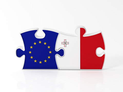 Jigsaw puzzle pieces textured with European Union and Maltese flags on white. Horizontal composition with copy space. Clipping path is included.