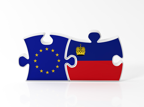 Jigsaw puzzle pieces textured with European Union and Liechtenstein flags on white. Horizontal composition with copy space. Clipping path is included.