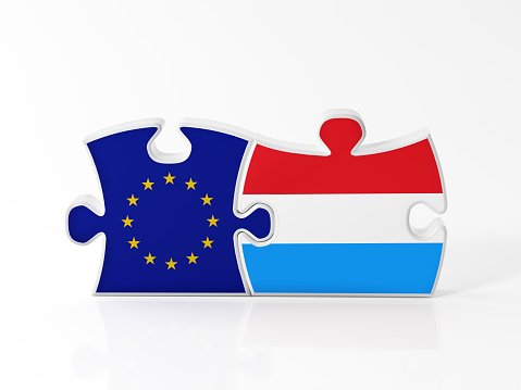 Jigsaw puzzle pieces textured with European Union and Luxembourg flags on white. Horizontal composition with copy space. Clipping path is included.