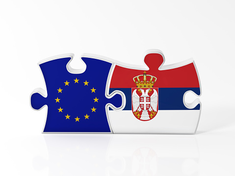 Jigsaw puzzle pieces textured with European Union and Serbian flags on white. Horizontal composition with copy space. Clipping path is included.