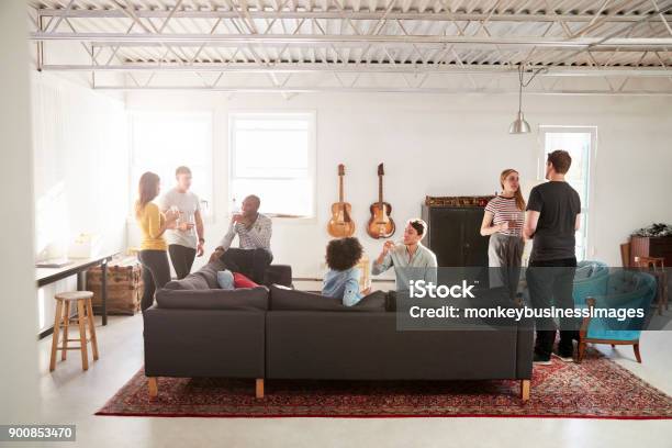 Friends At A Party In A New York Loft Apartment Full Length Stock Photo - Download Image Now