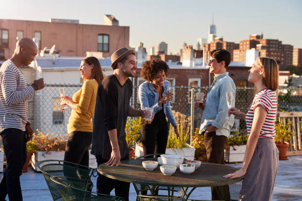 istock Friends stand talking at a party on a New York rooftop 900853564