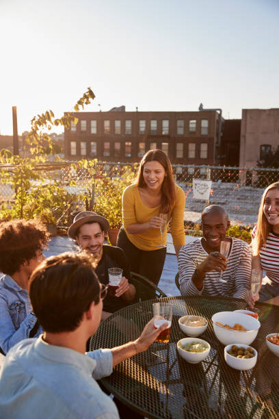 istock Friends talking at a party on a rooftop, vertical 900853568