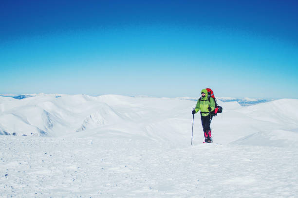 istock Winter hike in the mountains with a backpack and tent. 900860960
