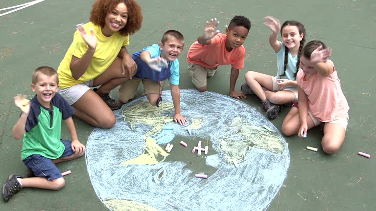 Multi-ethnic children making chalk drawing of earth