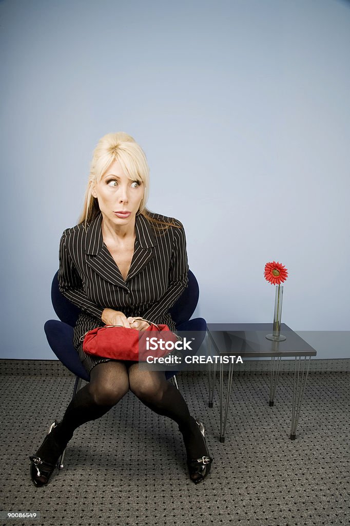 Apprehensive woman sitting waiting in an office chair  Embarrassment Stock Photo