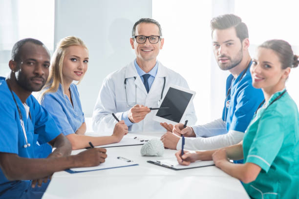 istock doctors sitting at conference desk 900865716