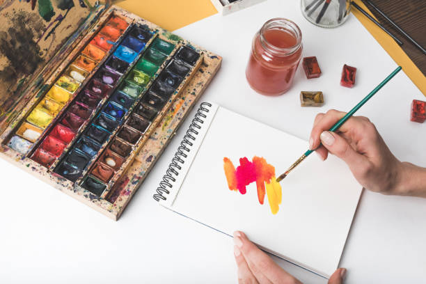 istock partial view of hands drawing abstract painting at designer workplace 900870318