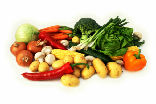 Variety of fresh organic vegetables on white background.