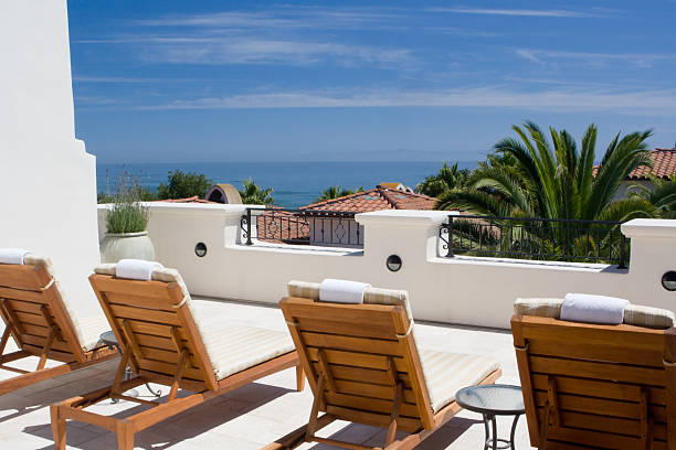 Lounge chairs on a white balcony facing the ocean stock photo