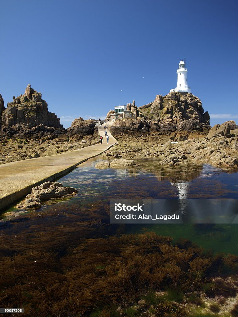 Corbiere Lighthouse, New Jersey, reflected in bay waters Tourist spot of headland shot with 28mm lens and polarizer, Jersey - England Stock Photo
