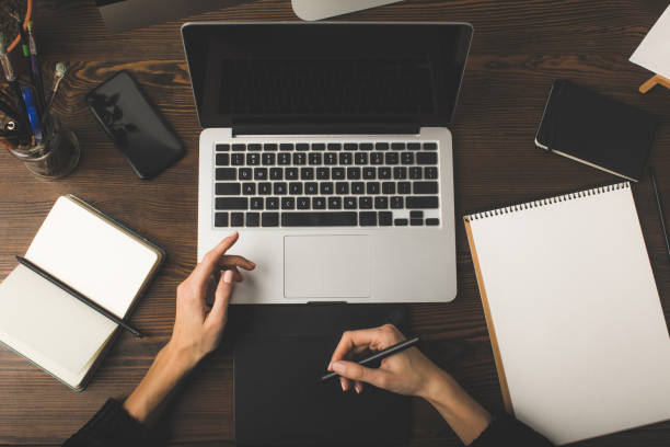 istock top view of designer using laptop and graphics tablet at workplace 900872712