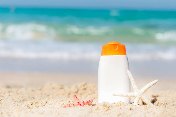 istock Protective sunscreen or sunblock and sunbath lotion in white plastic bottles on tropical beach, summer accessories in holiday, copy space.  Summer Concept 900873008
