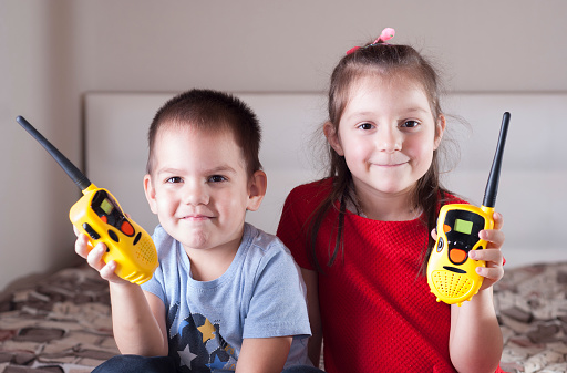 children girl and boy playing with walkie-talkie