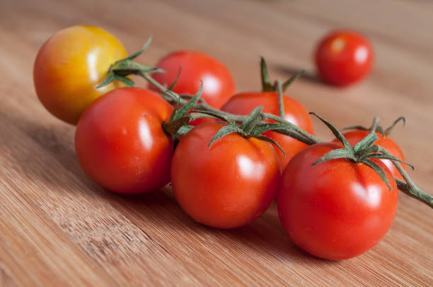 istock cherry tomatoes on wooden cutting board in bambou texture 900880606