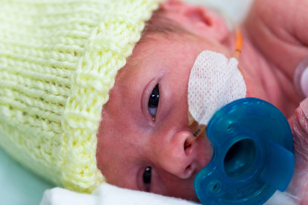 istock Premature baby in the neonatal intensive care unit with a pacifier 900881032