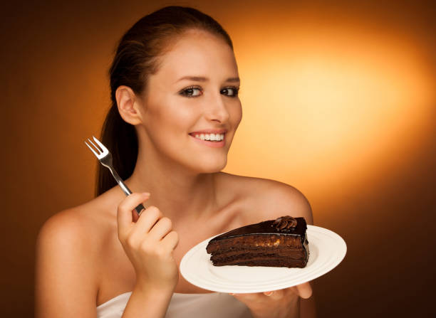 istock chocolate cake - glamorous woman eats dessert 900881928