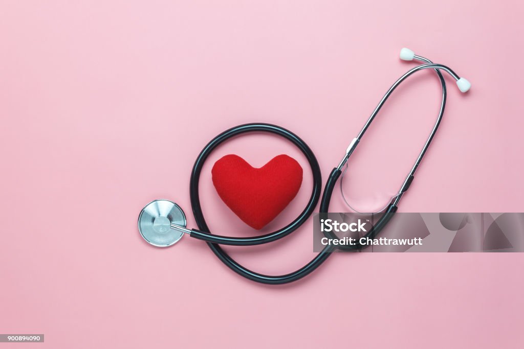 Table top view shot of arrangement equipment medical background concept.Red heart & stethoscope on modern rustic pink paper.An idea essential accessories for doctor for  care patient  in hospital. Heart - Internal Organ Stock Photo