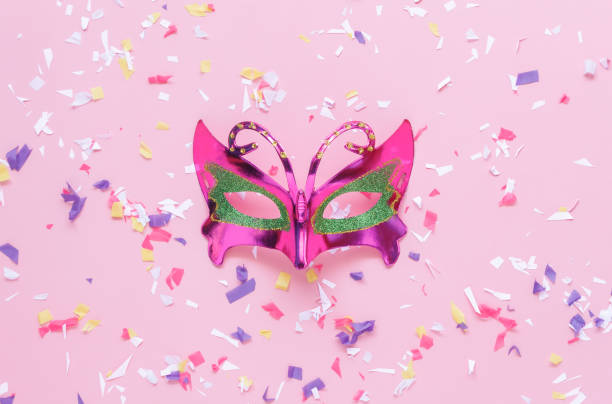 istock Table top view aerial image of beautiful silver carnival mask background.Accessory object on modern rustic pink wallpaper at home office desk studio.free space for creative design text and font. 900894536