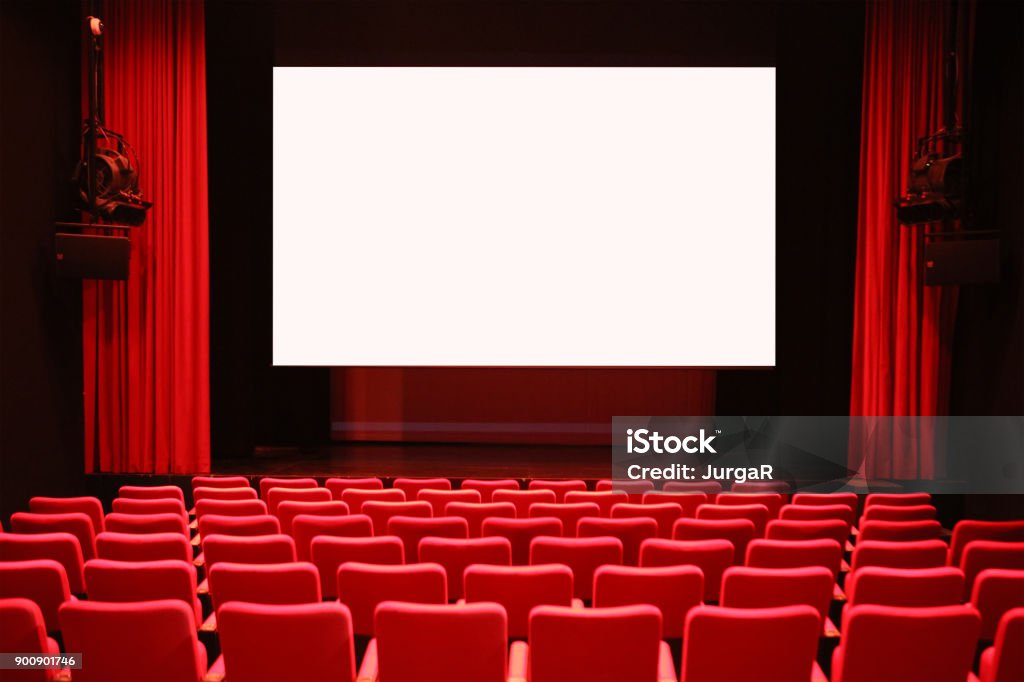 Empty Cinema Room with Red Seats and Blank Screen Empty cinema room with red seats and a white screen Movie Theater Stock Photo