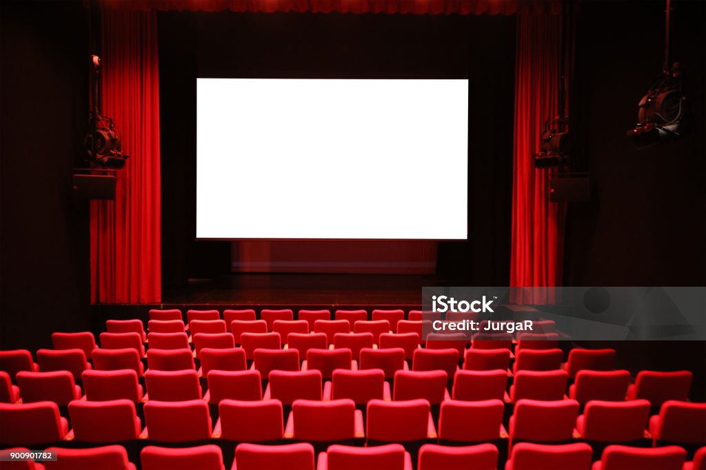 Cinema with Red Seats and Blank Screen Empty cinema room with red seats and a blank white screen Movie Theater Stock Photo