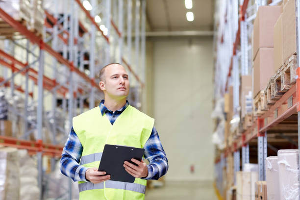 istock man with clipboard in safety vest at warehouse 900903942