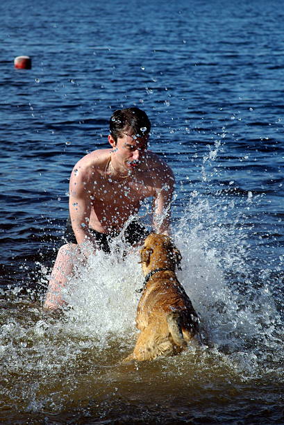 istock Man plays with dog in water 90090423