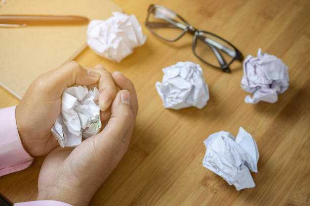 istock Crumpled paper ball in hand on office table 900912864