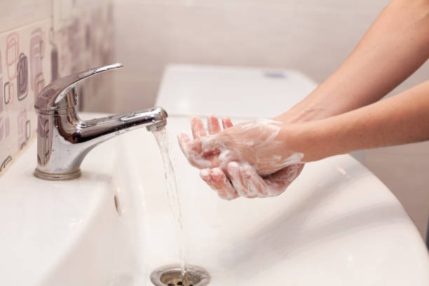 A woman is soaping her hands with soap. Hygiene. Washing hands in the bathroom A woman is soaping her hands with soap. Hygiene. Washing hands in the bathroom bacterial mat stock pictures, royalty-free photos & images