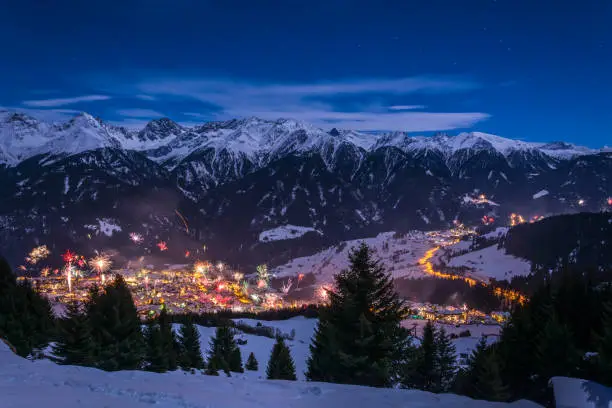 New Years Eve fireworks over village Fiss in Austria with snowy mountains and stars