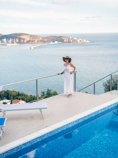 istock Woman by poolside enjoying view 900924876