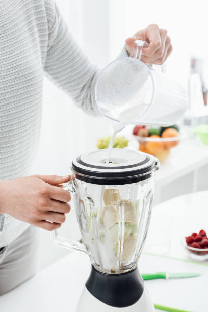 istock Woman preparing smoothie with milk 900925294
