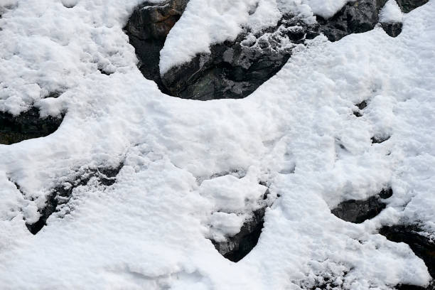 istock Vertical mountain slope with rocks covered with fresh snow - background texture 900926264