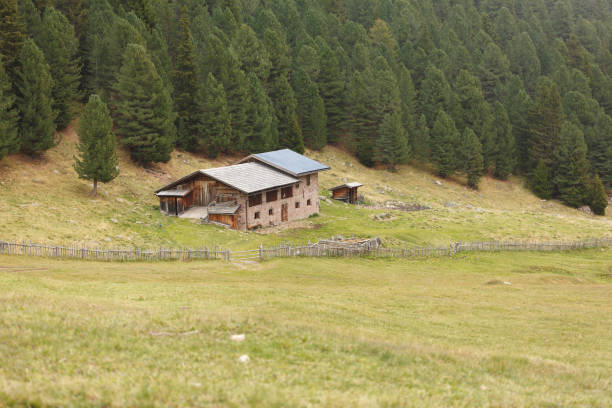 wiejska scena ze schronienia z panelami fotowoltaicznymi wśród górskich pastwisk w val di funes, włochy - footpath european alps fence woods zdjęcia i obrazy z banku zdjęć