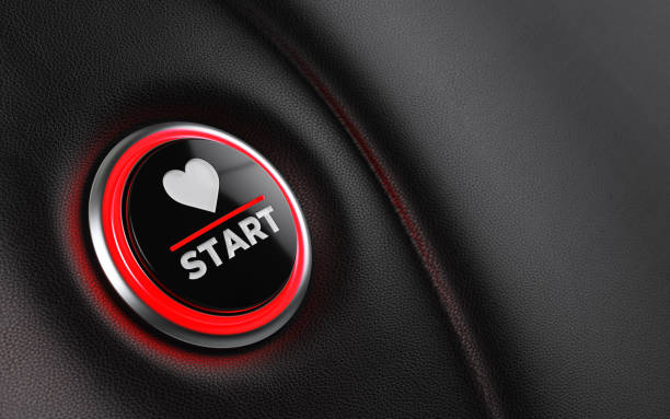 Car start button on dashboard. There is a heart shape on push button. Horizontal composition with copy space and selective focus. Valentine's Day concept.