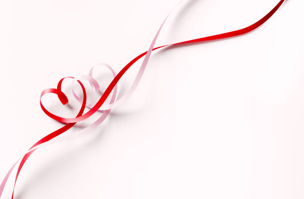 Valentines Day concept. Heart shaped ribbons tangled on white background. Horizontal composition with  and copy space. Clipping path is included.