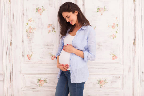 jeune femme attend un bébé. grossesse. - human pregnancy baby shower image color image photos et images de collection
