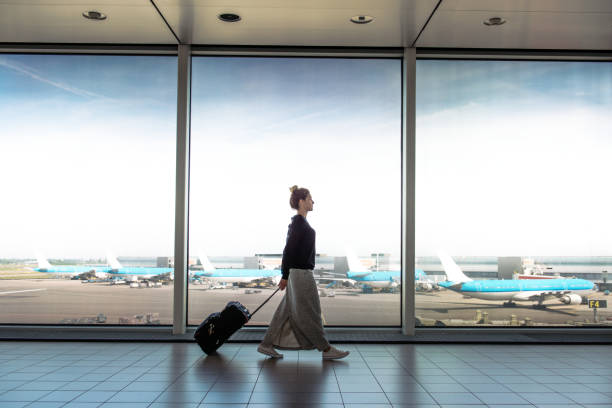 wanita dengan koper akan naik pada penerbangan berikutnya - airport potret stok, foto, & gambar bebas royalti