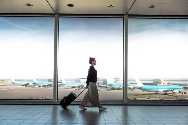 Photo of Woman with suitcase is going to board on the next flight