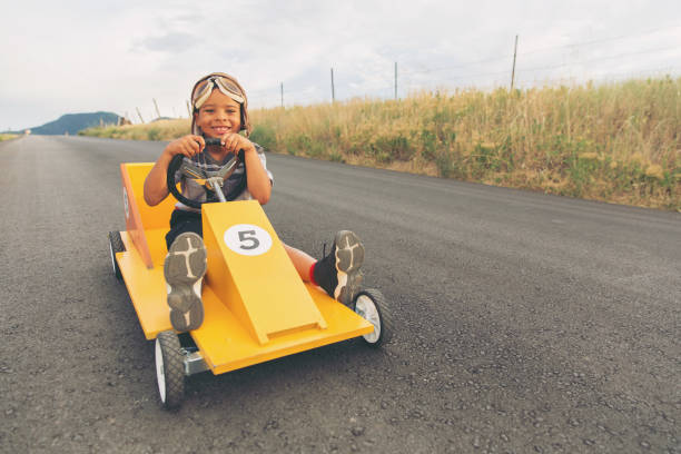 istock Young Boy Racing Homemade Car 900969442