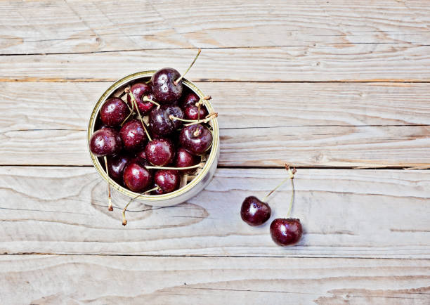 istock Ripe cherry in a metalic jar on wooden table 900971928